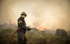 A firefighter prepares to battle a blaze during veld fires in Ocean View. Picture: Thomas Holder/EWN