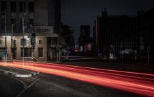 Trails of lights from passing vehicles in Braamfontein, Johannesburg while the area is submerged in darkness due to load shedding. Picture: AFP