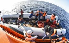 FILE: Men evacuate a rubber boat with the help of the crew of the Topaz Responder ship run by Maltese NGO Moas and the Italian Red Cross during a rescue operation of migrants. Picture: AFP.