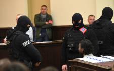 Prime suspect in the November 2015 Paris attacks Salah Abdeslam (L) sits as he surrounded by Belgian special police officers in the courtroom at the "Palais de Justice" courthouse in Brussels for the opening of his trial, on 5 February, 2018. Picture: AFP