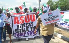 FILE: Workers and civil society groups carry placards as they march during a protest demanding that the government reinstate prices of fuel at 86.50 naira ($0.43, 0.38 euros) per litre in Lagos, on 18 May, 2016. Picture: AFP.