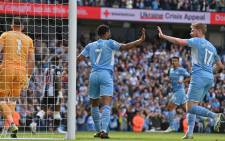 Manchester City midfielder Raheem Sterling (C) celebrates scoring the opening goal with teammate Kevin De Bruyne during the English Premier League football match between Manchester City and Newcastle United at the Etihad Stadium in Manchester, north west England, on 8 May 2022. Picture: Paul ELLIS/AFP