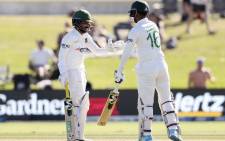 Bangladesh's batsmen Mominul Haque (L) and Liton Das bump the gloves between the overs during day three of the first cricket Test match at the Bay Oval in Mount Maunganui on 3 January 2022. Picture: MICHAEL BRADLEY/AFP