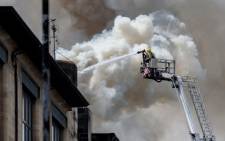 FILE: A firefighter douses the fire at the Charles Rennie Mackintosh building housing the Glasgow School of Art in Glasgow, Scotland on May 23, 2014. Picture: AFP.