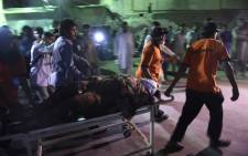 Pakistani rescuers transport an injured victim to the hospital in Karachi on 12 November, 2016, following a suicide bombing at a Sufi shrine. Picture: AFP.