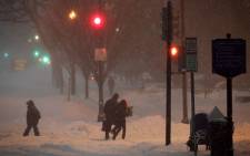 People walk in the snow on 23 January, 2016 in Washington, DC. Heavy snow continued to fall in the Mid-Atlantic region causing "life-threatening blizzard conditions" and affecting millions of people. Picture: AFP.