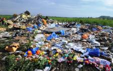 Flowers and toys are left at the site of the crash of a Malaysia Airlines plane carrying 298 people from Amsterdam to Kuala Lumpur in Hrabove, in rebel-held eastern Ukraine, on 19 July 2014. Picture: AFP.