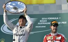 Mercedes AMG Petronas F1 Team’s German driver Nico Rosberg celebrates his victory at the podium as Ferrari’s German driver Sebastian Vettel applauds following the Formula One Australian Grand Prix in Melbourne on 20 March, 2016. Picture: AFP.