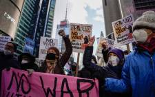 Demonstrators hold signs during a protest against US military involvement with Russia over Ukraine during a rally in Times Square on 5 February 2022. Picture: AFP