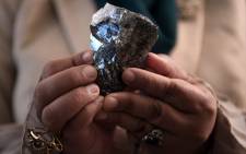 A member of the Botswana cabinet holds a 1,174-carat diamond in Gaborone, Botswana, on July 7, 2021, that Canadian mining firm Lucara found during an 11-day production run in June 2021. Picture: Monirul Bhuiyan / AFP.