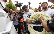 Brazil's former football star Ronaldinho (C) lays a wreath of flowers in remembrance of members of the Lebanese civil defence that were killed almost a year prior during the blast that rocked the port of Lebanon's capital Beirut, at the Beirut fire brigade headquarters near the port blast site on 29 July 2021. Picture: AFP