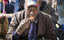 An elderly man eats his parcel of food from Gift of the Givers at Joubert Park on Mandela Day. Picture: Thomas Holder/EWN