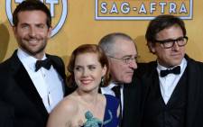 UNITED STATES, Los Angeles : FROM LEFT: Bradley Cooper, Amy Adams, Robert DeNiro and director David O. Russell, members of the cast of "American Hustle," winner of the Best Cast in a Motion Picture award, pose in the press room at the 20th annual Screen Actors Guild Awards, January 18, 2014 at the Shrine Auditorium in Los Angeles, California. Picture: AFP