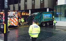 A rubbish truck is seen wedged into the wall of the Millennium Hotel in George Square in central Glasgow, Scotland on December 22, 2014. Several people were reported killed and injured in Glasgow on Monday when a lorry ploughed into Christmas shoppers in the city centre in an apparent accident. Picture: AFP.