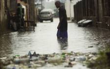 A man walks through water after rains flooded the streets in a neighborhood of Kinshasa, Congo. Picture: AFP.