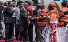 Eritrea’s Foreign Minister Osman Saleh Mohammed (C) walks with Ethiopia’s Prime Minister Abiy Ahmed (L) shaking hands with dignitaries as an Eritrean delegation for peace talks with Ethiopia arrives at the international airport in Addis Ababa on 26 June 2018. Picture: AFP