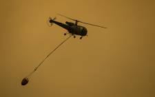 A helicoper water bombing the flames in the Jonkershoek valley on 11 March 2015. Picture: Aletta Gardner/EWN