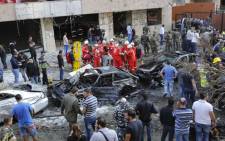 Onlookers watch as Lebanese rescue teams and security forces inspect the scene of a powerful blast in southern Beirut near the Iranian embassy. Picture: AFP.