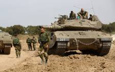 FILE: Israeli soldiers stand guard with their tank along the border between Israel and the Gaza Strip near the southern Israeli Kibbutz of Nahal Oz. Picture: AFP.