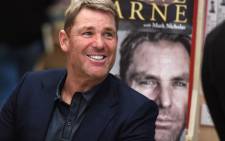 FILE: Australian cricketing great Shane Warne chats with a customer during a book signing event for his new autobiography titled "No Spin", in Melbourne on 19 October 2018. Picture: AFP