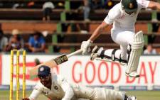 Indian fielder Shikhar Dhawan attempts to runout South African batsman Alviro Petersen on the fourth day of the first cricket Test between South Africa and India at the Wanderers Stadium in Johannesburg on December 21, 2013. Picture: AFP.