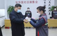FILE: This photo released on 10 February 2020 by China's Xinhua News Agency shows Chinese President Xi Jinping (L) wearing a protective facemask as a health official (R) checks his body temperature during an inspection of the novel coronavirus pneumonia prevention and control work at the Anhuali Community in Beijing. Picture: AFP.
