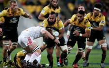 Loni Uhila (C) of the Hurricanes is tackled by Sam Cane (C bottom) of the Chiefs during the Super Rugby semi-finals match between the Wellington Hurricanes and Waikato Chiefs at Westpac Stadium in Wellington on July 30, 2016. Picture: AFP