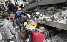 FILE: Members of the Syrian Civil Defence, also known as the "White Helmets", search the rubble of a collapsed building following an explosion in the town of Jisr al-Shughur, in the west of the mostly rebel-held Syrian province of Idlib, on 24 April 2019. Picture: AFP