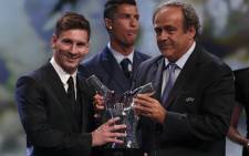 FC Barcelone Argentinian striker Lionel Messi (L) receives from UEFA president Michel Platini (R) the trophy of Best Men's player in Europe next to runner-up Portugal's Cristiano Ronaldo at the end of the UEFA Champions League Group stage draw ceremony, on August 27, 2015 in Monaco. Picture: AFP.