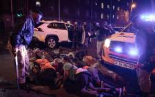 Metro police officers gather people that they have arrested in Hillbrow waiting for vehicles to transport them to cells.  People were made to lie on their stomachs.  Picture: Boikhutso Ntsoko/ Eyewitness News.