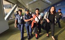 Philippine journalist Maria Ressa (2nd R), is escorted by police after an arrest warrant was served, shortly after arriving at the international airport in Manila on 29 March 2019. Ressa, a prominent critic of President Rodrigo Duterte, was arrested on a fraud charge, a colleague said on Ressa, a prominent critic of Duterte. Picture: AFP