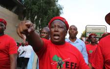 EFF leader Julius Malema leads his party members through the barriers erected outside the JSE in Sandton during their march against South Africa's financial sector. Picture: Reinart Toerien/EWN.