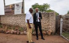The SAHRC's Buang Jones (right) with a SAPS official discussing the commission's right to enter the Nyati Bush and Riverbreak resort in Brits on 21 January 2020. Picture: Abigail Javier/EWN