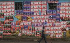 A man walks next to campaign posters of various candidates pasted on the walls, in Nairobi, on 2 August 2022, ahead of Kenya's August 2022 general election. Picture: Simon MAINA/AFP