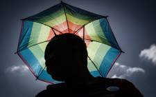 A member of the South African lesbian, gay, bisexual and transgender and intersex (LGBTI) community holding an umbrella in the rainbow flag colours takes part in the annual Gay Pride Parade, as part of the Durban Pride Festival, on 29 June 2019 in Durban. Picture: Rajesh JANTILAL/AFP