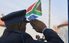 FILE: One of the police trainees salute as the South African flag is raised during a graduation parade. Picture: SAPS