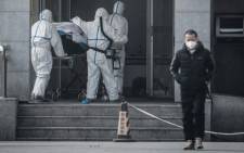 FILE: Medical staff members carry a patient into the Jinyintan hospital, where patients infected by a mysterious SARS-like virus are being treated, in Wuhan in China's central Hubei province on January 18, 2020. Picture: AFP.