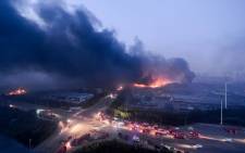 ire and smoke rises at the site of the massive explosions in Tianjin on 13 August 2015. Picture: AFP.