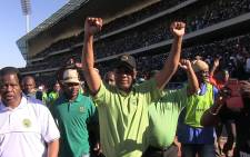 Amcu President Joseph Mathunjwa raises his hands triumphantly at the Royal Bafokeng stadium near Rustenburg as miners agree to sign a wage agreement on 23 June 2014. Picture: Reinart Toerien/EWN.