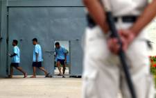 A prison police stands guard with a baton as he watches inmates enter a compound at Bangkok's Klong Prem Prison. Picture: AFP