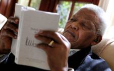 Former South African President Nelson Mandela is pictured reading a book by Debbie Yazbek/Nelson Mandela Foundation/SAPA