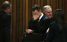 FILE: Oscar Pistorius hides his face during his court appearance on 5 March 2014. Picture: Pool.