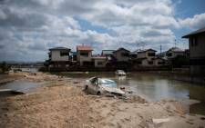 A damaged car is seen stuck in the mud in a flood hit area in Mabi, Okayama prefecture on 10 July, 2018. Picture: AFP