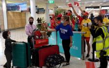 Staff offer souvenirs to passengers upon arrival at the Sydney International Airport on 21 February 2022, as Australia reopened its borders for fully vaccinated visa holders, tourists, and business travellers. Picture: SAEED KHAN/AFP