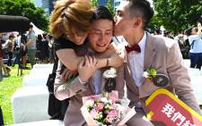 Shane Lin (C) is comforted by his partner Marc Yuan (R) and a friend during a wedding ceremony in Shinyi district in Taipei on 24 May 2019. Picture: AFP