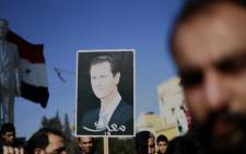 Syrian demonstrators hold a portrait of President Bashar al-Assad during a demonstration in the northeastern Syrian Kurdish-majority city of Qamishli on 23 December, 2018, asking for the Syrian army's protection as Turkey threatens to carry out a fresh offensive following the US decision to withdraw their troops. Picture: AFP
