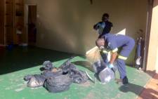SAPS forensics officials pack away bags of methaquelone at a Bryanston house. Picture: Matshidiso Madia/EWN 