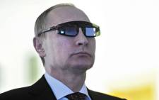 Russian President Vladimir Putin, wearing special glasses, looks on as he visits a laboratory at the Gornyy National Mineral Resources University in St. Petersburg, 2015. Picture: AFP