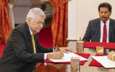 This handout photograph taken on 12 May 2022 and released by Sri Lanka President's Office shows the new prime minister Ranil Wickremesinghe (L) attending his swearing in ceremony at the President's Palace in Colombo. Picture: Sri Lanka President's Office / AFP