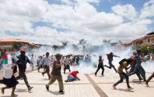 Supporters of Madagascan presidential candidate Marc Ravalomanana scramble as security forces fire tear gas during a demonstration to protest election results on 2 January 2019. Picture: AFP